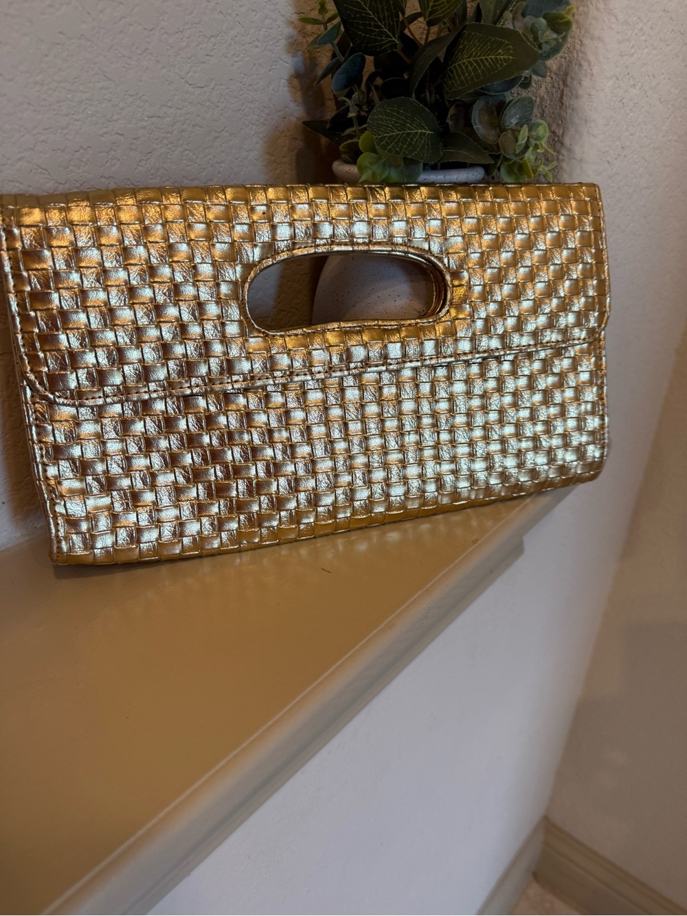Woven faux leather clutch in metallic gold